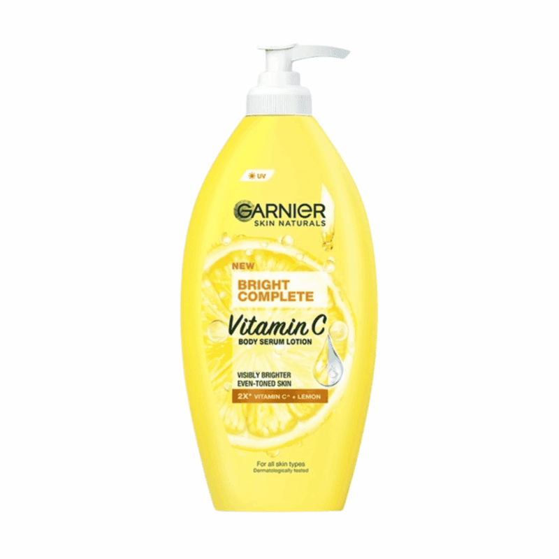 Yellow Garnier Skin Naturals Bright Complete Vitamin C body serum lotion bottle with a white pump, featuring lemon and vitamin C graphics on the label against a white background.