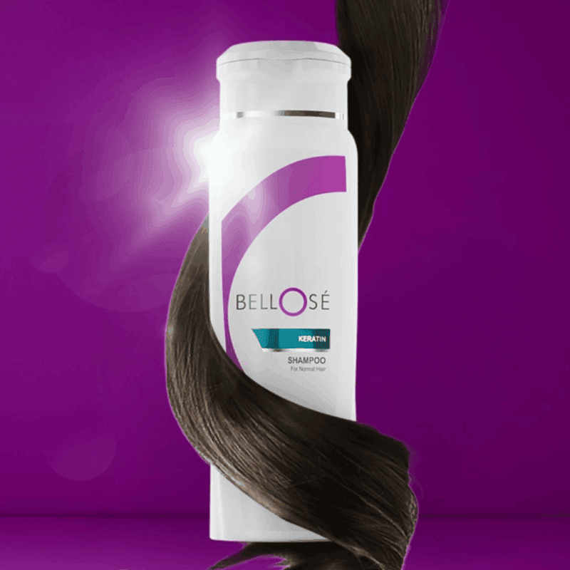 Bellose Keratin shampoo bottle with a white and purple label, wrapped by a smooth dark hair strand, displayed against a purple background to highlight shine and keratin hair care benefits.