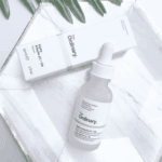 The Ordinary Alpha Arbutin 2% + HA serum with box flat lay on white surface