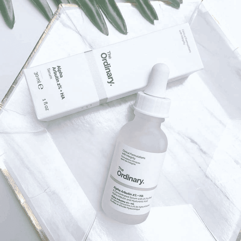 The Ordinary Alpha Arbutin 2% + HA serum with box flat lay on white surface