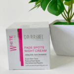 Dr Rashel Fade Spots Night Cream packaging with arbutin and niacinamide beside a potted plant on white background