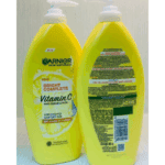 Two yellow Garnier Skin Naturals Bright Complete Vitamin C body serum lotion bottles shown side by side, one displaying the front label with lemon graphic and “2X Vitamin C + Lemon,” and the other showing the back packaging with ingredients, usage instructions, barcode, and 400ml volume details.