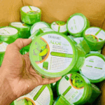 Hand holding Dr. Rashel Aloe Vera Soothing and Moisturizing Gel jar with multiple sealed jars packed in a cardboard box