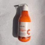 Dr Rashel Vitamin C body lotion bottle photographed in sunlight showing orange lotion and pump dispenser