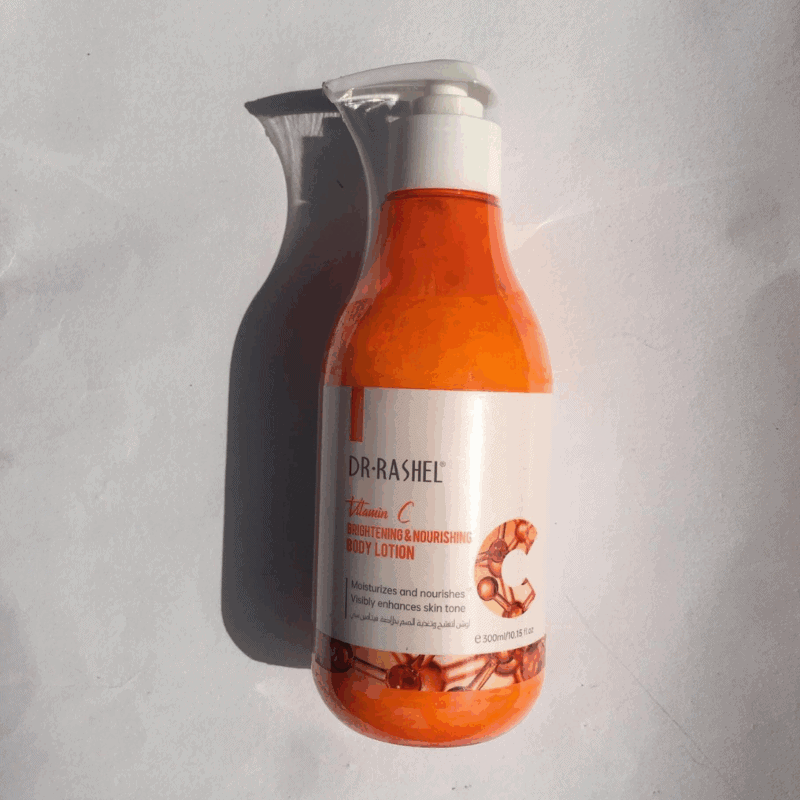 Dr Rashel Vitamin C body lotion bottle photographed in sunlight showing orange lotion and pump dispenser