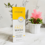 Dr. Rashel Vitamin C brightening face wash box placed on marble surface with decorative plant background