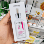 Dr. Rashel White Skin Whitening Fade Spots Serum packaging held in hand inside a store, showing product branding and serum illustration.