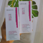 Two Dr. Rashel White Skin Whitening Fade Spots Serum boxes held in hand, highlighting arbutin and niacinamide formula.