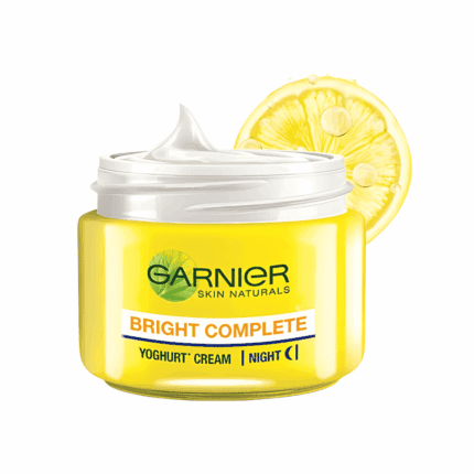 Open Garnier Bright Complete Vitamin C yoghurt night cream showing creamy texture with lemon slice on white background