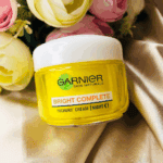 Garnier Bright Complete Vitamin C yoghurt night cream in yellow jar with white lid on soft fabric background