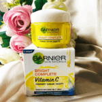 Garnier Bright Complete Vitamin C yoghurt night cream jar placed on product box with floral background