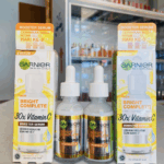 Garnier Bright Complete 30x Vitamin C Booster Serum bottles displayed between original boxes on a store counter