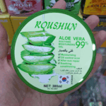 Close-up of Roushun Aloe Vera 99% soothing moisturizing gel lid held in hand showing aloe slices and product details.