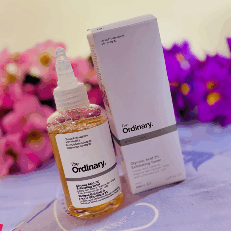 The Ordinary Glycolic Acid 7% Exfoliating Toner bottle beside original box on a soft floral background