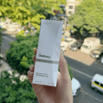 The Ordinary Glycolic Acid 7% Exfoliating Toner box held in hand with trees and street view behind