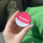 Vaseline Rosy Lips Lip Therapy 17g tin held in hand, showing front label inside a car