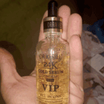 Dr. Rashel 24K Gold VIP serum bottle held in hand showing gold flakes inside