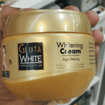 Close up of Gluta White whitening cream jar showing age defying formula with glutathione and collagen