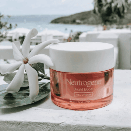 Neutrogena Bright Boost gel cream placed outdoors with white flower and ocean view in background