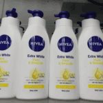 Multiple NIVEA Extra White Firm and Smooth body lotion bottles displayed on a retail shelf