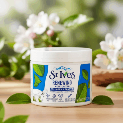 St. Ives Renewing Moisturizer with Collagen and Elastin placed on a wooden surface with green leaves and flowers