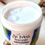 Open St. Ives Renewing Moisturizer jar showing creamy white moisturizer texture inside