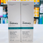 Two boxes of The Ordinary Multi-Peptide Serum for Hair Density standing side by side on a counter