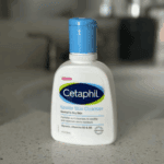 Hand holding Cetaphil Gentle Skin Cleanser 59ml showing front label in real-life setting