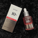 Anua Niacinamide 10% TXA 4% serum bottle displayed next to original box on dark background
