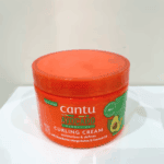 Real photo of cantu avocado hydrating curling cream jar placed on white surface