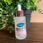 Cetaphil Healthy Radiance Brightening Serum 30ml placed on a table with green plant background