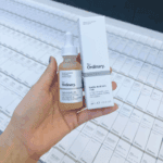 Hand holding The Ordinary Lactic Acid 10% + HA 2% 30ml serum with product box
