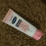 Cetaphil Bright Healthy Radiance Gentle Renewing Cleanser 100g tube placed on woven mat, brightening face wash for sensitive skin that purifies and refines skin texture.