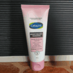 Cetaphil Bright Healthy Radiance Gentle Renewing Cleanser 100g tube for sensitive skin placed on surface, brightening face wash that purifies and refines skin texture for radiant skin.