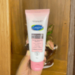 Hand holding Cetaphil Bright Healthy Radiance Gentle Renewing Cleanser 100g tube, brightening face wash for sensitive skin that purifies and refines skin texture.
