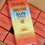 Dr Rashel Sun Cream Whitening SPF 75 60g sunscreen box packaging with long lasting UVA UVB protection and oil control placed on stacked product boxes.