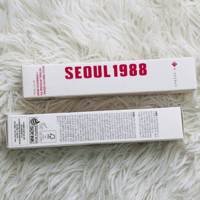 K-Secret Seoul 1988 Eye Cream 30ml box packaging displayed on a soft white fur background showing front and back sides.