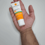 Small tube of La Roche-Posay Anthelios XL SPF 60 sunscreen resting on an open hand, showing compact travel size.