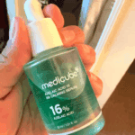 Hand holding Medicube Azelaic Acid 16% BB Calming Serum 30ml dropper bottle for acne and redness calming Korean skincare in Sri Lanka