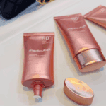 Medicube Collagen Firming Sun Cream SPF50+ PA++++ sunscreen tubes displayed on table.