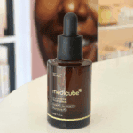 Medicube Glutathione Glow Serum 30g brightening serum bottle with dropper on wooden table.