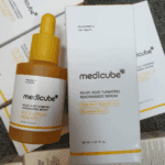 Medicube Kojic Acid Turmeric Niacinamide Serum 30ml yellow dropper bottle displayed with its white product box and additional packaging in the background.