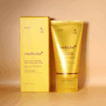 Medicube Kojic Acid Turmeric Night Wrapping Mask 75ml tube displayed next to its yellow box packaging on a warm beige background.