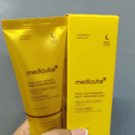 Yellow Medicube Kojic Acid Turmeric Night Wrapping Mask tube held next to its matching yellow product box, highlighting ingredients like kojic acid, vitamin C, retinol, turmeric, and collagen for overnight skincare.
