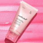 Medicube PDRN Pink Caffeine Night Wrapping Mask 75ml pink tube placed on a textured pink background, highlighting overnight skincare with PDRN, caffeine, and niacinamide.