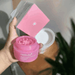 Hand holding Medicube PDRN Pink Collagen Capsule Cream jar with pink collagen capsules and product box.
