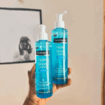Hand holding two Neutrogena Hydro Boost Water Gel Cleanser bottles with hyaluronic acid, hydrating face wash that boosts hydration and leaves skin refreshed and soft.