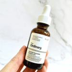 Hand holding The Ordinary Ascorbyl Glucoside Solution 12% 30ml vitamin C brightening serum bottle